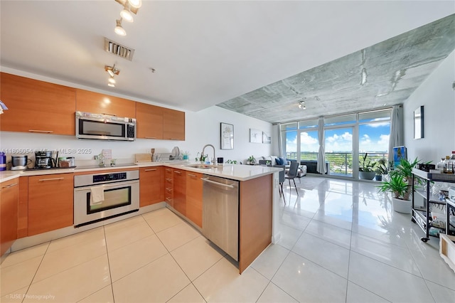 3250 NE 1st Ave Unit 1007, Miami, FL 33137 - kitchen featuring stainless steel appliances, a peninsula, open floor plan, light countertops, and floor to ceiling windows