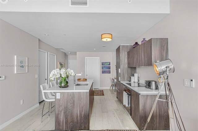 480 NE 31st St Unit 4804, Miami, FL 33137 - kitchen with modern cabinets, a kitchen bar, light countertops, and light wood-type flooring
