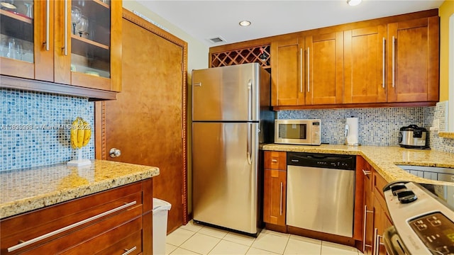 401 Ocean Dr Unit 722, Miami Beach, FL 33139 - kitchen featuring appliances with stainless steel finishes, light stone countertops, decorative backsplash, light tile patterned floors, and recessed lighting