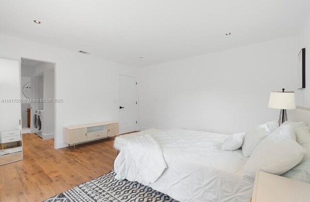309 SE 3rd Ave, Hallandale Beach, FL 33009 - bedroom with stacked washer / dryer, light wood-style flooring, and recessed lighting