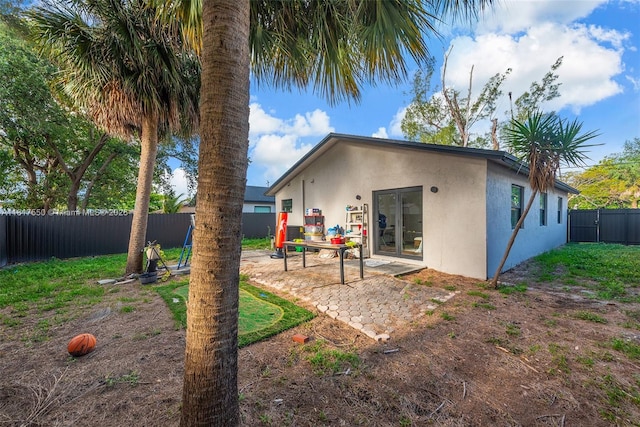 309 SE 3rd Ave, Hallandale Beach, FL 33009 - back of property featuring stucco siding, a patio area, a fenced backyard, and french doors