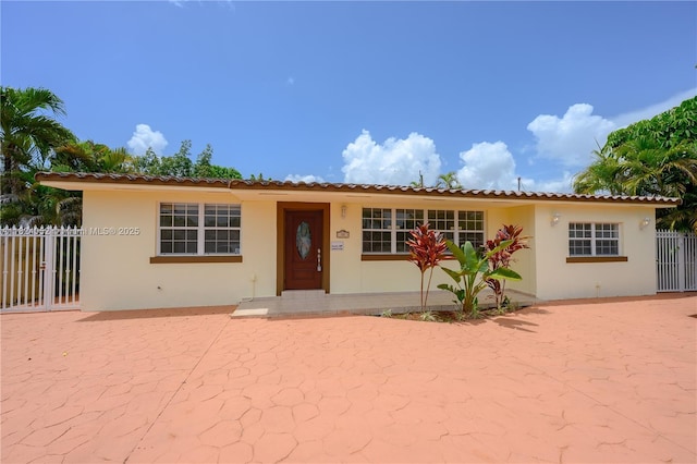 30 E 52nd Pl, Hialeah, FL 33013 - view of front of property with stucco siding, a patio, and a tiled roof