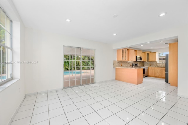 30 E 52nd Pl, Hialeah, FL 33013 - kitchen with stainless steel appliances, tasteful backsplash, glass insert cabinets, recessed lighting, and light countertops