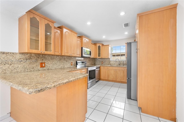 30 E 52nd Pl, Hialeah, FL 33013 - kitchen featuring stainless steel appliances, a peninsula, decorative backsplash, glass insert cabinets, and light tile patterned floors