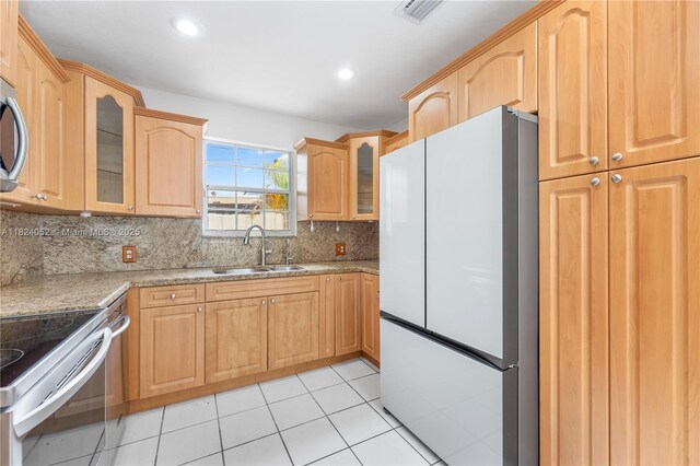 30 E 52nd Pl, Hialeah, FL 33013 - kitchen with stainless steel appliances, glass insert cabinets, decorative backsplash, light tile patterned floors, and recessed lighting