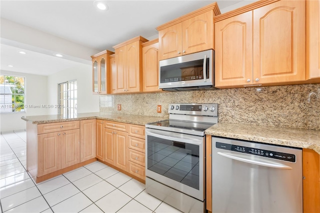 30 E 52nd Pl, Hialeah, FL 33013 - kitchen with stainless steel appliances, light brown cabinetry, a peninsula, backsplash, and recessed lighting