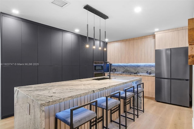 11530 NE 7th Ave, Biscayne Park, FL 33161 - kitchen with freestanding refrigerator, modern cabinets, light brown cabinets, light stone counters, and recessed lighting