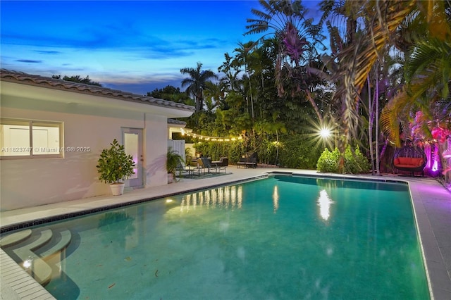 11530 NE 7th Ave, Biscayne Park, FL 33161 - pool at dusk featuring an outdoor pool and a patio