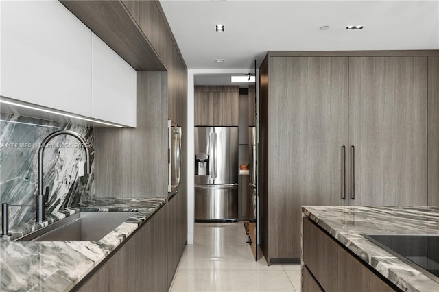 6000 Island Blvd Unit Ph7, Aventura, FL 33160 - kitchen featuring modern cabinets, stainless steel refrigerator with ice dispenser, light stone countertops, light tile patterned floors, and black electric stovetop