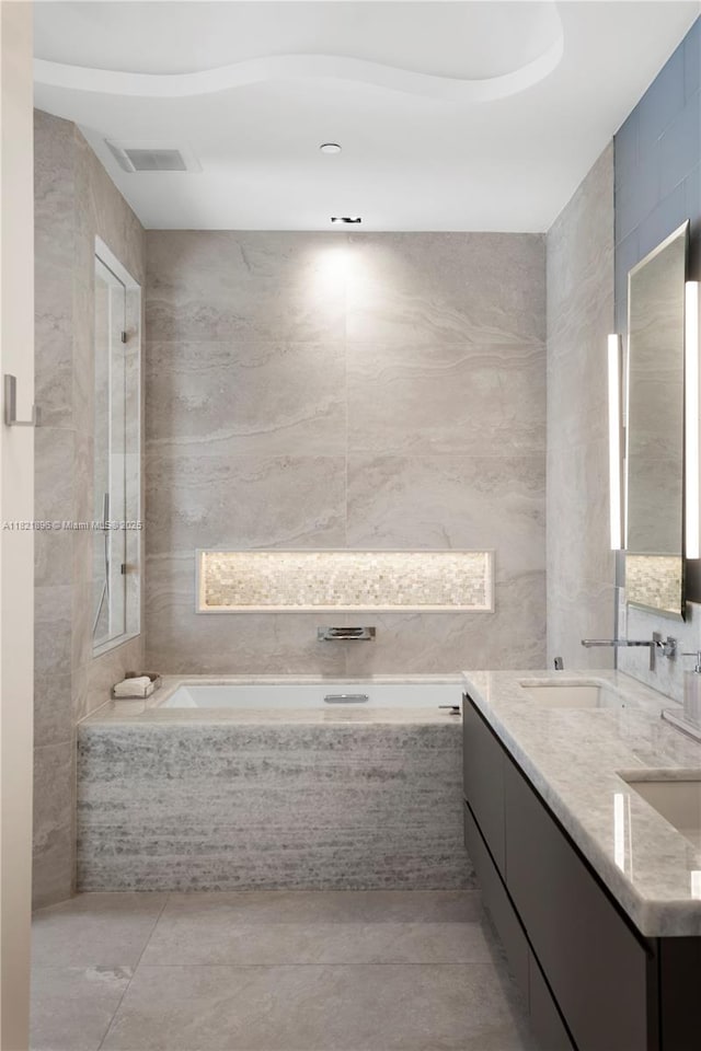 6000 Island Blvd Unit Ph7, Aventura, FL 33160 - full bathroom featuring a bath, double vanity, tile walls, and tile patterned flooring