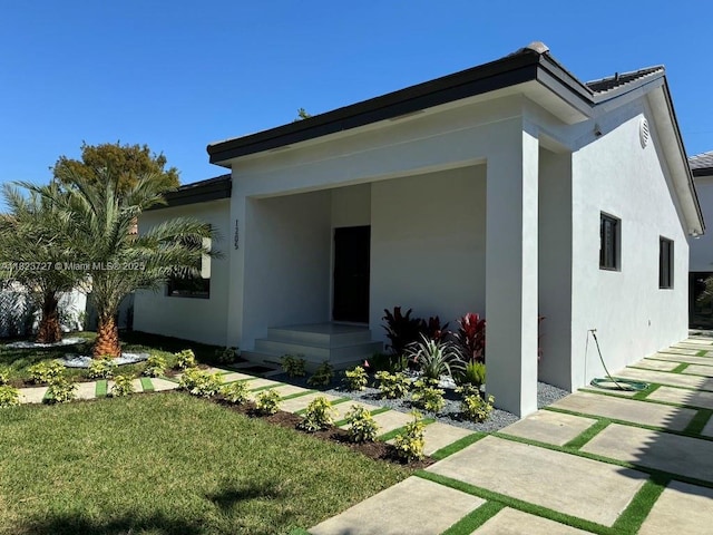1205 Wallace St, Coral Gables, FL 33134 - back of house featuring stucco siding and a lawn