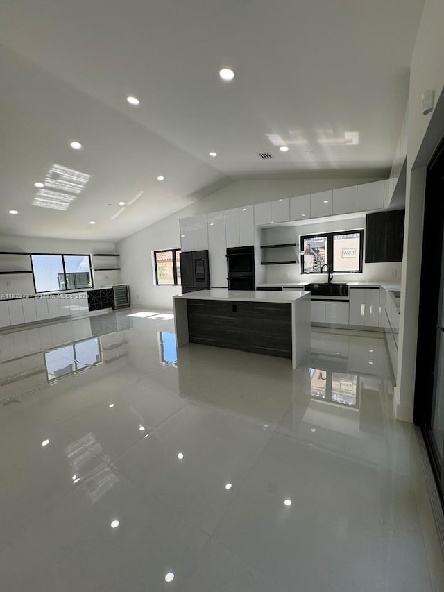 1205 Wallace St, Coral Gables, FL 33134 - kitchen featuring modern cabinets, white cabinetry, lofted ceiling, refrigerator, and a kitchen island