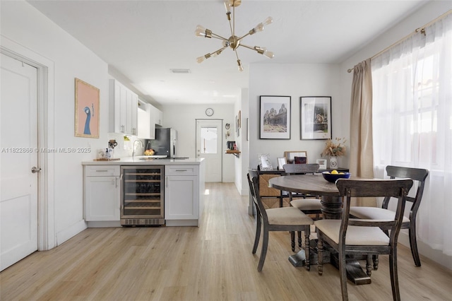 3422 SW 25th St, Miami, FL 33133 - dining space featuring beverage cooler, light wood-style flooring, and a chandelier