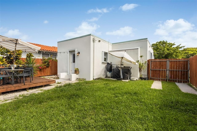 3422 SW 25th St, Miami, FL 33133 - back of property with a fenced backyard, stucco siding, a gate, and a deck
