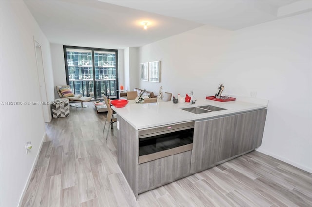 801 S Miami Ave Unit 3108, Miami, FL 33130 - kitchen with expansive windows, modern cabinets, light countertops, light wood-type flooring, and a peninsula