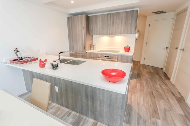 801 S Miami Ave Unit 3108, Miami, FL 33130 - kitchen with modern cabinets, stainless steel oven, light countertops, a peninsula, and light wood-style floors