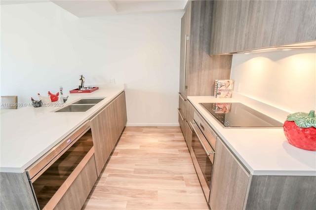 801 S Miami Ave Unit 3108, Miami, FL 33130 - kitchen with modern cabinets, beverage cooler, black electric cooktop, light wood finished floors, and light countertops