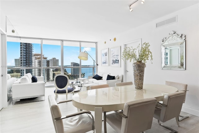 465 Brickell Ave Unit 2003, Miami, FL 33131 - dining room with wood finished floors, expansive windows, a view of city, and rail lighting
