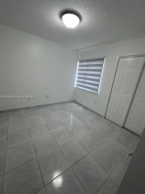 641 SW 99th Pl, Miami, FL 33174 - empty room featuring a textured ceiling and light tile patterned flooring