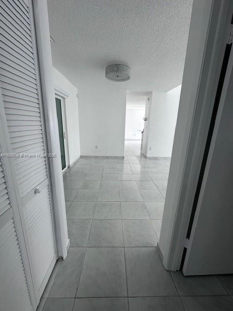 641 SW 99th Pl, Miami, FL 33174 - hallway featuring light tile patterned floors and a textured ceiling
