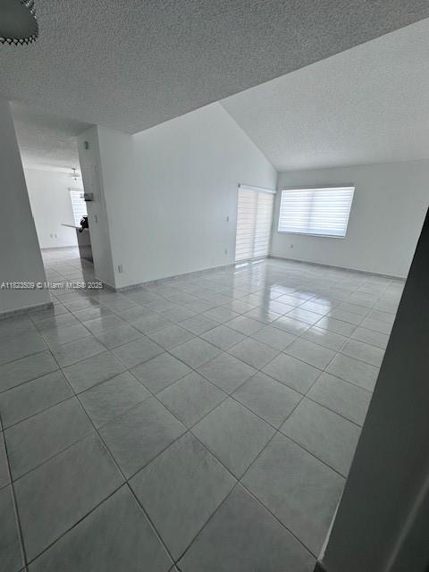 641 SW 99th Pl, Miami, FL 33174 - empty room featuring tile patterned flooring, a textured ceiling, and vaulted ceiling