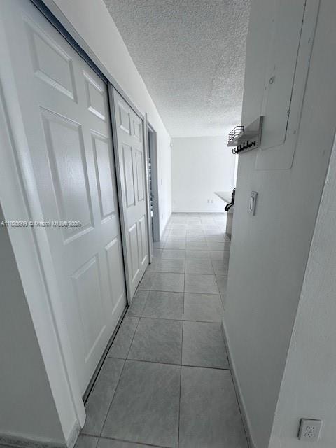 641 SW 99th Pl, Miami, FL 33174 - corridor with a textured ceiling and light tile patterned floors