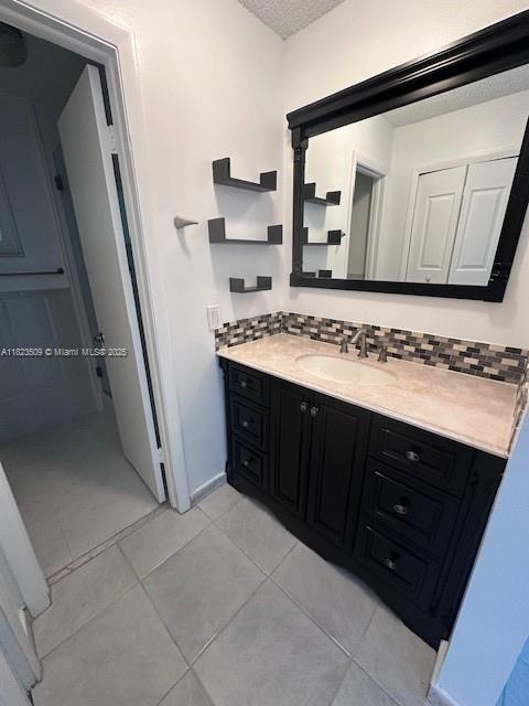 641 SW 99th Pl, Miami, FL 33174 - bathroom featuring vanity, tile patterned flooring, a textured ceiling, and backsplash