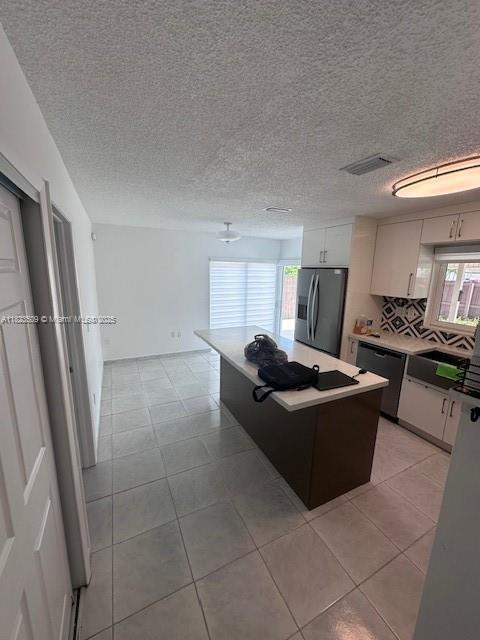 641 SW 99th Pl, Miami, FL 33174 - kitchen with stainless steel refrigerator with ice dispenser, dishwasher, healthy amount of natural light, a center island, and a textured ceiling