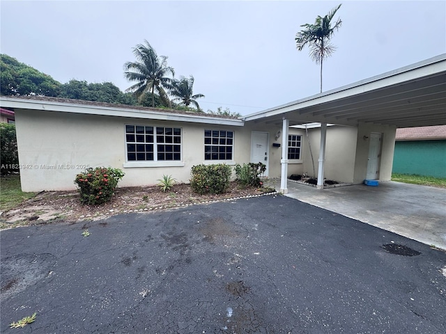 423 SW 10th Ave, Boynton Beach, FL 33435 - view of front facade with stucco siding, a carport, and driveway