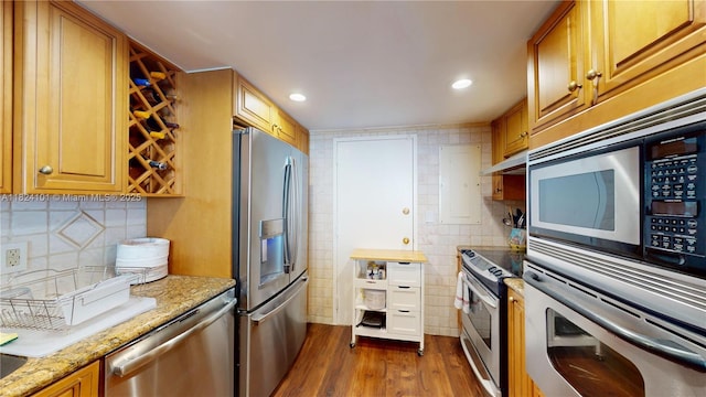 11113 Biscayne Blvd Unit 1055, Miami, FL 33181 - kitchen featuring appliances with stainless steel finishes, dark wood-style floors, light stone counters, under cabinet range hood, and tasteful backsplash