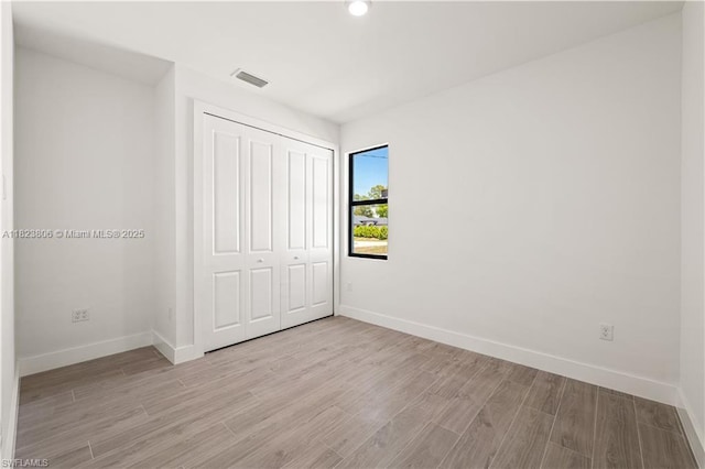 3305 18th St W, Lehigh Acres, FL 33971 - unfurnished bedroom featuring light wood-type flooring, a closet, and recessed lighting