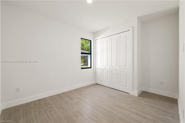 3305 18th St W, Lehigh Acres, FL 33971 - unfurnished bedroom with light wood finished floors and a closet