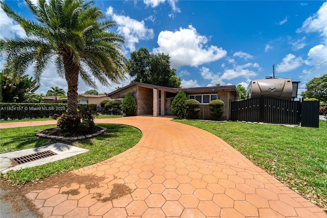 3404 Garden Ln, Miramar, FL 33023 - view of front facade with a fenced front yard, curved driveway, and a gate