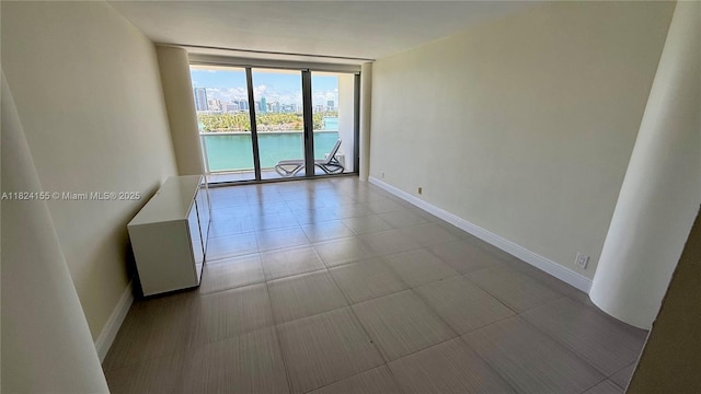 900 Bay Dr Unit 906, Miami Beach, FL 33141 - spare room with a wall of windows and baseboards