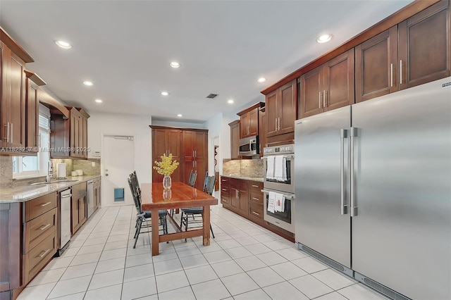7340 SW 123rd Ter, Pinecrest, FL 33156 - kitchen with appliances with stainless steel finishes, backsplash, recessed lighting, light stone countertops, and light tile patterned floors