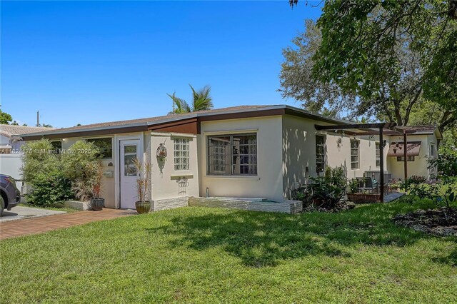 1395 NE 178th St, North Miami Beach, FL 33162 - view of front of home with a front yard, stucco siding, and a pergola