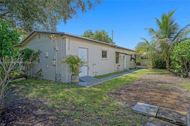 1395 NE 178th St, North Miami Beach, FL 33162 - rear view of property with stucco siding and a yard