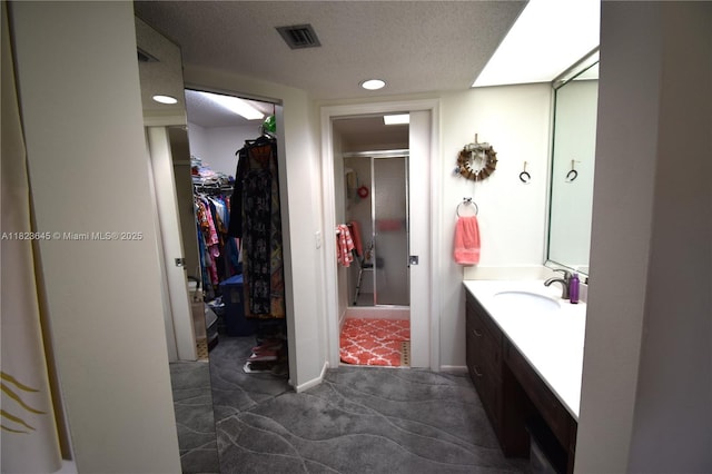 100 SW 130th Unit 311C, Pembroke Pines, FL 33027 - full bathroom featuring a walk in closet, vanity, a stall shower, a textured ceiling, and recessed lighting