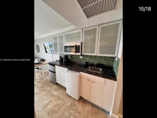 19201 Collins Ave, Sunny Isles Beach, FL 33160 - kitchen featuring stainless steel microwave, dishwasher, glass insert cabinets, backsplash, and ornamental molding