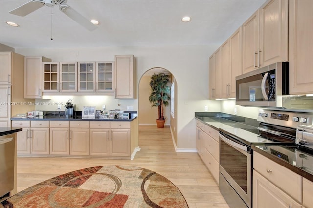 20406 SW 54th Pl, Pembroke Pines, FL 33332 - kitchen featuring stainless steel appliances, arched walkways, light wood-type flooring, dark countertops, and recessed lighting