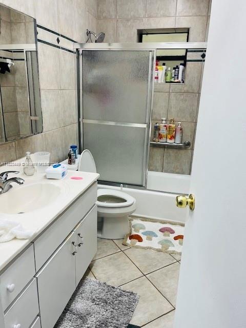 8701 SW 12th St Unit 30, Miami, FL 33174 - bathroom featuring vanity, enclosed tub / shower combo, tile patterned flooring, and tile walls