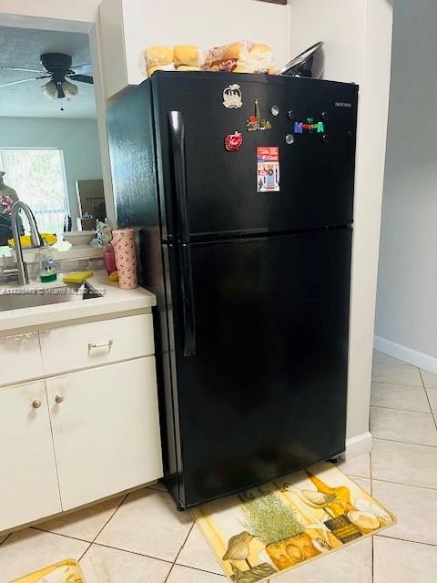 8701 SW 12th St Unit 30, Miami, FL 33174 - kitchen with freestanding refrigerator, light tile patterned floors, light countertops, a ceiling fan, and white cabinetry