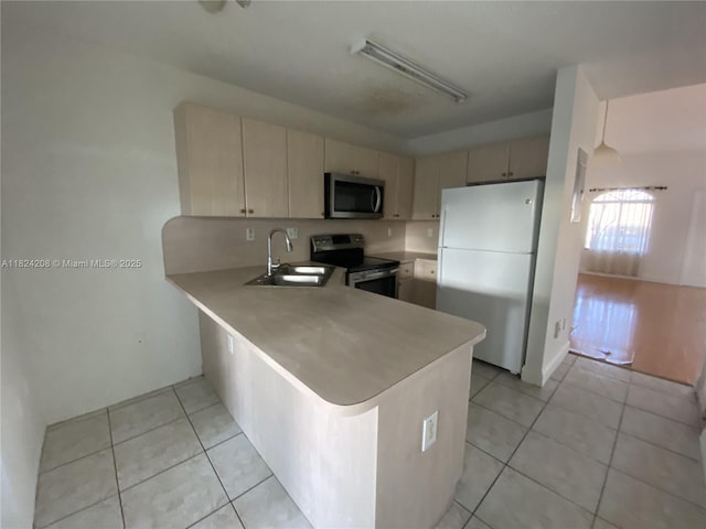 18942 NW 86th Ct, Hialeah, FL 33015 - kitchen featuring stainless steel appliances, light tile patterned flooring, a peninsula, light countertops, and cream cabinets