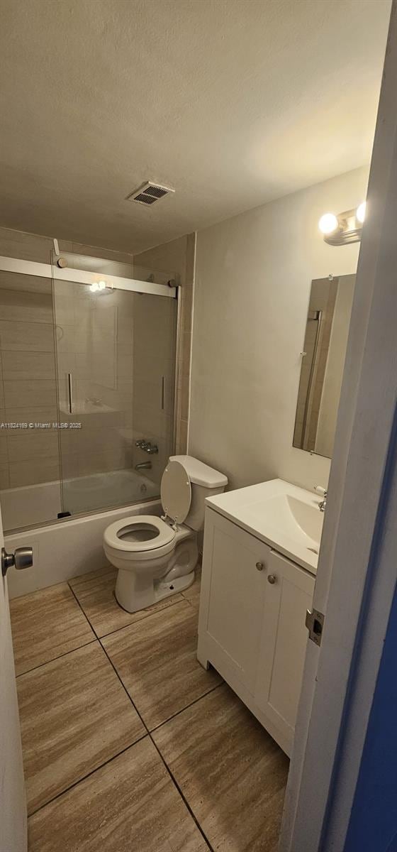 3660 NE 166th St Unit 503, North Miami Beach, FL 33160 - full bath with vanity, combined bath / shower with glass door, tile patterned floors, and a textured ceiling