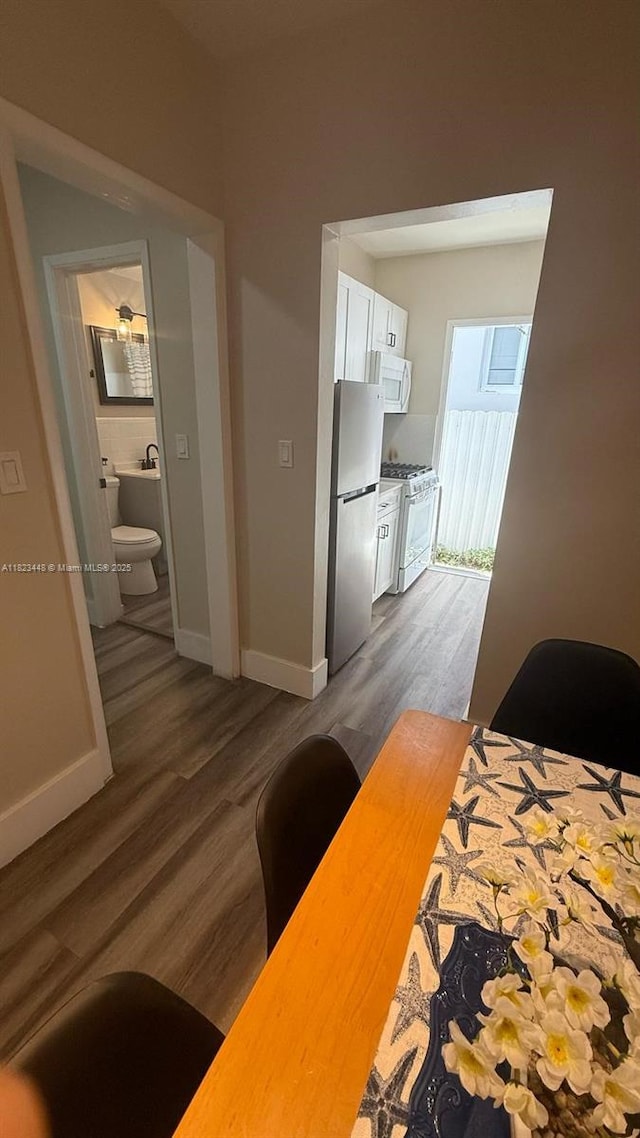 8132 Harding Ave Unit 2, Miami Beach, FL 33141 - bedroom featuring freestanding refrigerator, wood finished floors, and ensuite bath