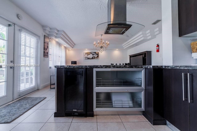 203 SE 8th St, Dania Beach, FL 33004 - kitchen with wine cooler, island exhaust hood, healthy amount of natural light, a tray ceiling, and a textured ceiling
