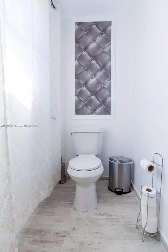 203 SE 8th St, Dania Beach, FL 33004 - bathroom with toilet and wood finished floors
