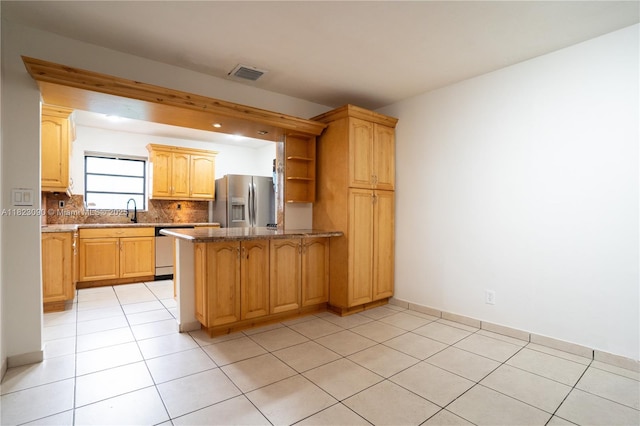 9351 SW 53rd St, Miami, FL 33165 - kitchen featuring stainless steel appliances, a peninsula, light tile patterned flooring, decorative backsplash, and dark stone countertops