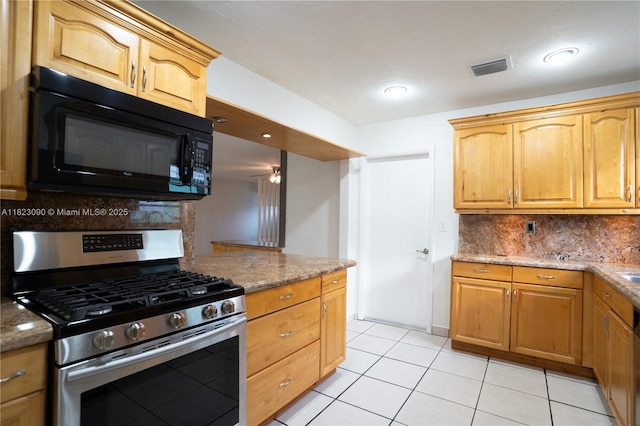 9351 SW 53rd St, Miami, FL 33165 - kitchen with stainless steel gas stove, black microwave, backsplash, light tile patterned floors, and stone countertops