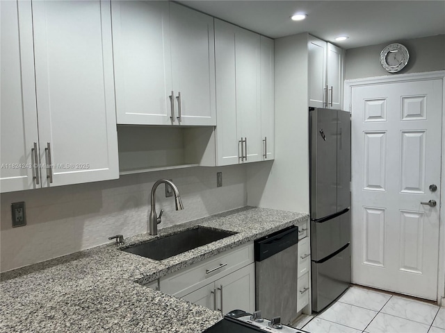1160 NE 191st St Unit 32, Miami, FL 33179 - kitchen with freestanding refrigerator, dishwasher, light stone counters, white cabinets, and recessed lighting